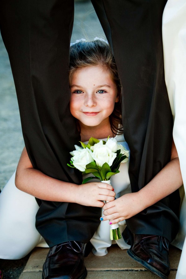 San Diego Wedding Photography: True Photography captures little flower girl hiding between dads legs duirng wedding in San diego 