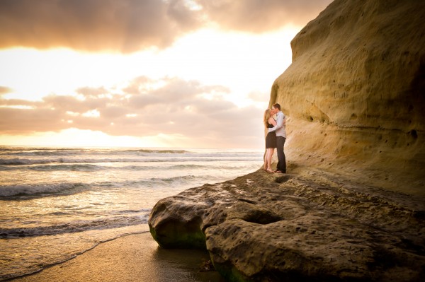 San Diego Wedding Photographer- engagement photoshoot on the cliffs at the beach kissing at sunset