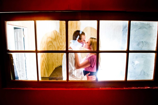 San Diego Wedding Photography of couple kissing behind a window at night