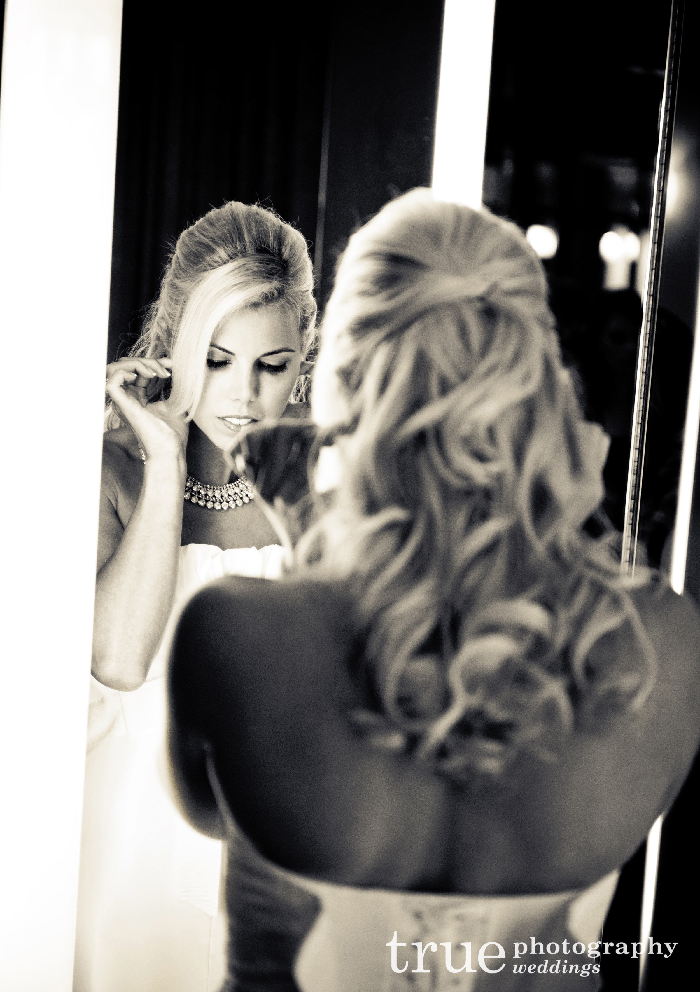 Orange County Photography- Bride getting ready looking in mirror before Pelican Hill wedding