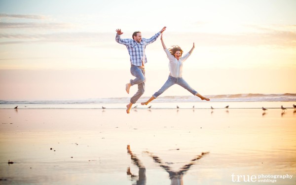 San Diego Wedding Photography: Jumping on the beach in fun beach engagement photos