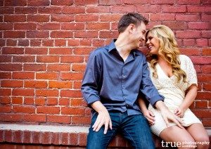San Diego Wedding Photography: Engagement Photos in front of brick wall in Downtown San Diego