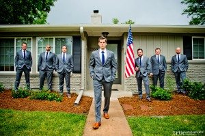 Groom Craig and his groomsmen standing with a flag