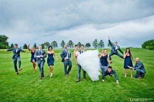 bridal party being playful in the green grass