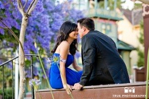 engagement photo shoot of Old Town Couple sitting with purple flowers