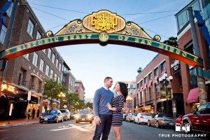 engaged couple standing underneath Gaslamp sign San Diego