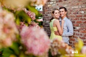 Old Town engagement shoot of couple near brick wall with flowers