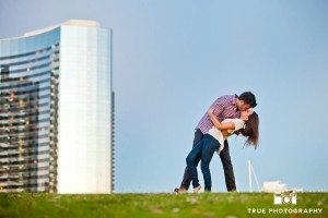 couple kissing on grass downtown San Diego engagement photo shoot