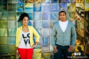 Engagement photo shoot of Mission Beach couplestanding against tiled background