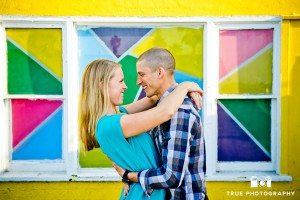 Engagement photo shoot of Pacific Beach couple with colorful mosaic background