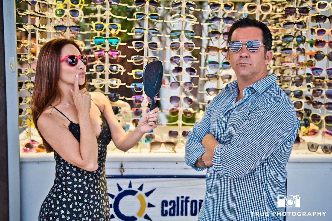 couple trying on sunglasses at Seaport Village Engagement Photo Shoot