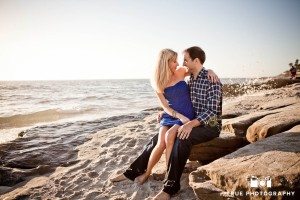 Windansea engagement photo shoot with couple sitting on sand
