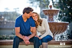 Engagement photo shoot of USD Campus couple sitting in front of fountain