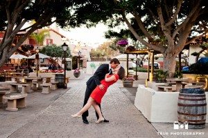 engaged couple kissing in Seaport Village
