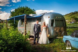 photo of bride and groom in front of airstream trailer