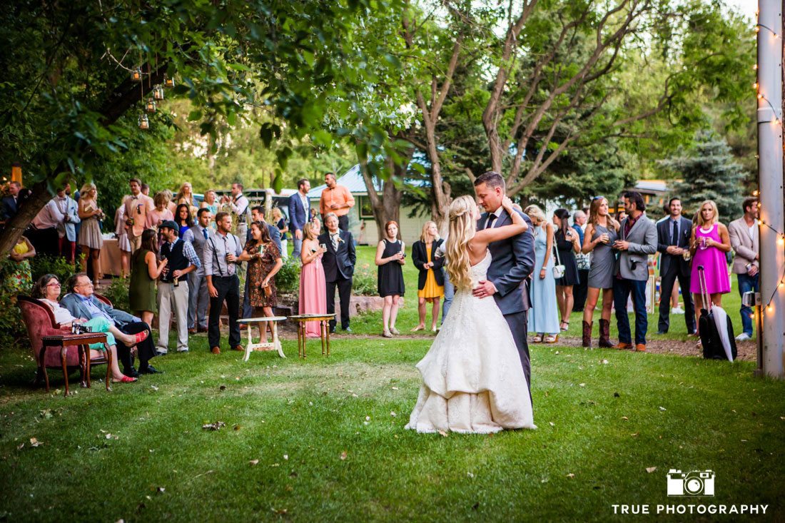 bride and groom dancing on green lawn