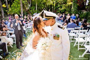 Bride and Groom kiss at end of wedding aisle