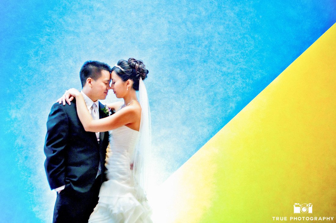 Creative Bride and Groom have a quiet moment in front of colorful wall