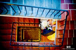 Bride and Groom lean in for an artistic photo of them kissing down stairwell