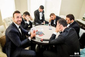 Groomsmen pose for fun photo playing poker before ceremony