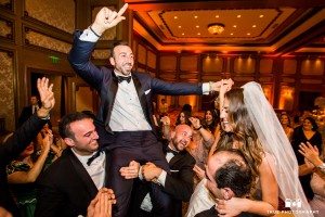 Groomsmen lift groom off ground during reception at Grand Del Mar