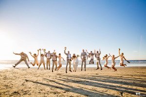 Bride, groom, and bridal party jumping photo