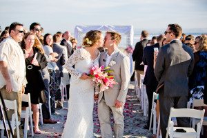 Wedding ceremony with bride and groom kissing during recessional at Coronado