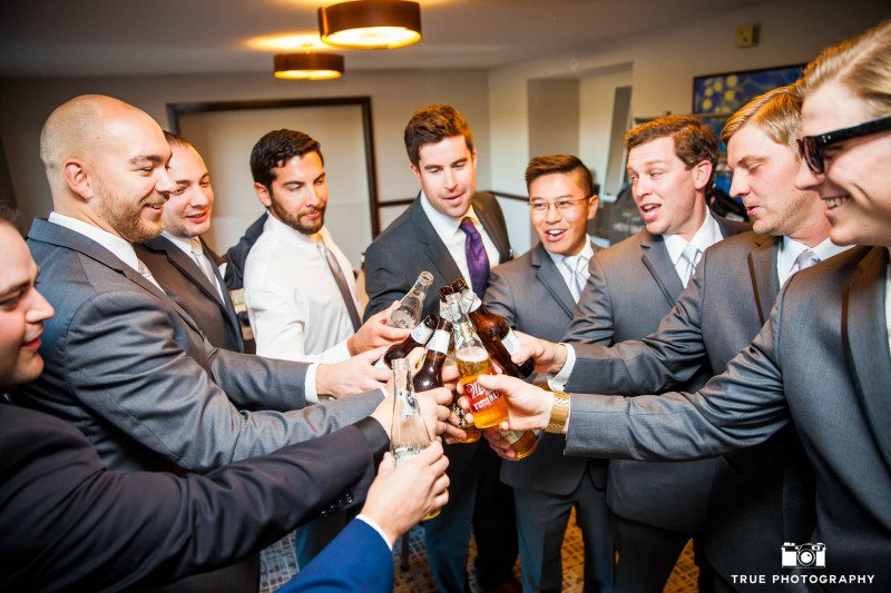 Groomsmen relax and cheers for a beer