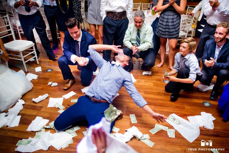 Groom takes shot and has money throw at him during wedding reception