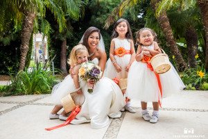 Flower girls in white tulle dresses with orange accents