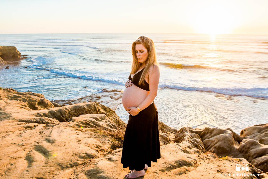 Stunning bare belly maternity photo at beach during sunset.