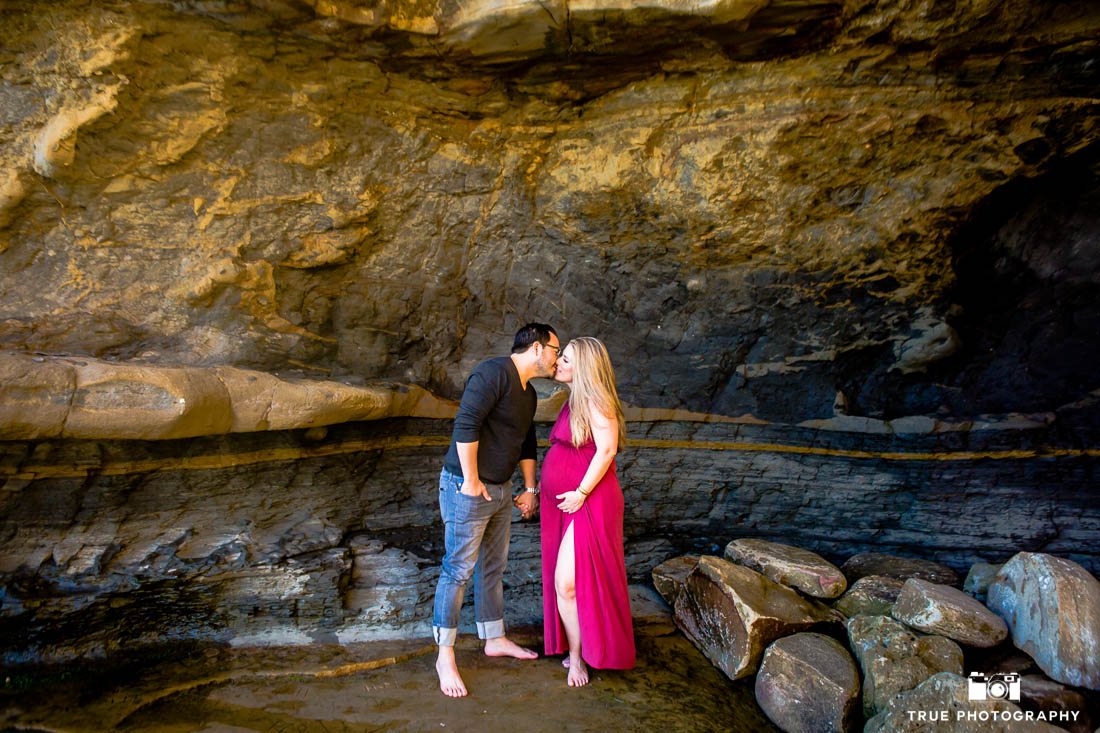 Husband and pregnant wife kissing during maternity photo session.