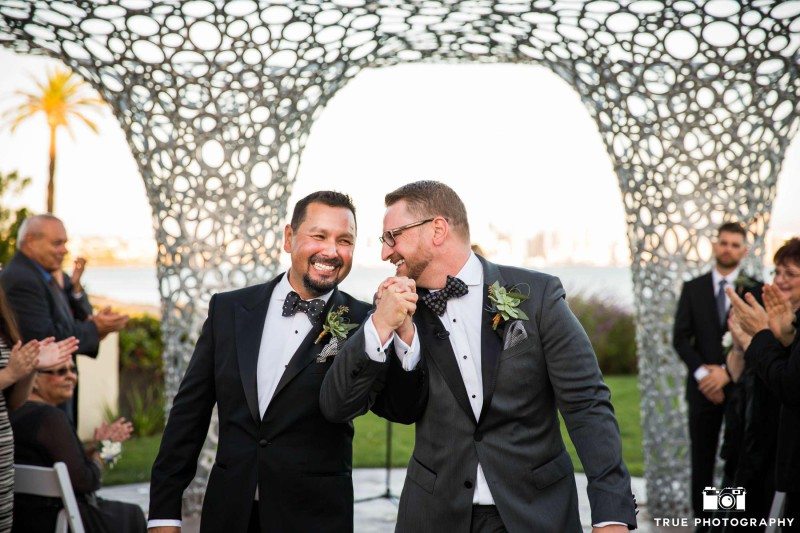 Gay couple announced just married and holding hands.