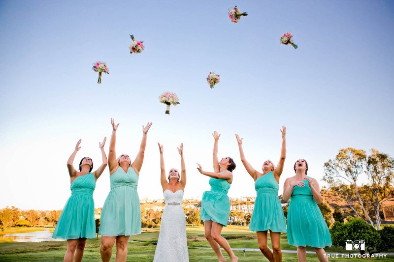Bridesmaids and Bride toss wedding bouquets up in air