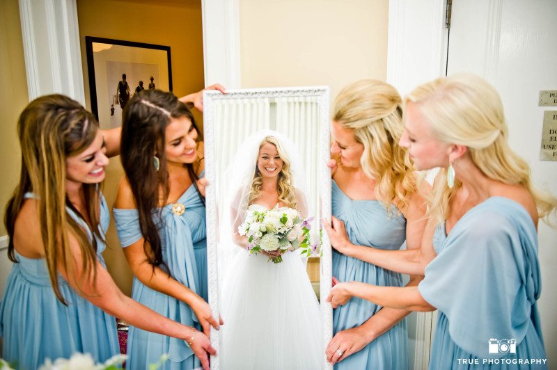 Bridesmaids hold up mirror for Bride to reveal herself