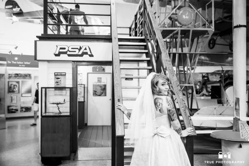 Bride climbs stairs up to Groom for First Look inside Air and Space Museum