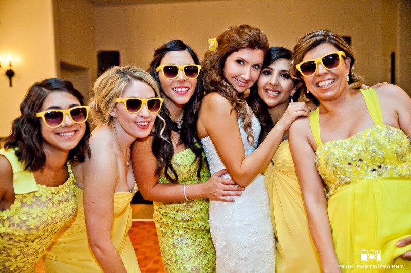 Bridesmaids pose with Bride and wear yellow sunglasses