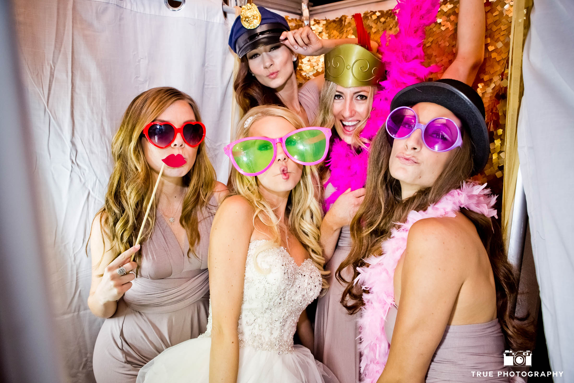 Bridesmaids pose with props in photobooth