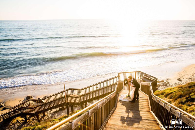 Cape Rey Hilton couple kissing on the stairs at Carlsbad beach