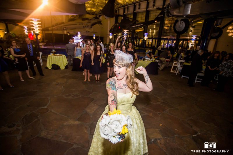 Bride holds out flowers for bouquet toss