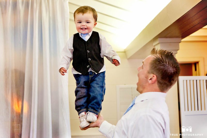 Funny photo of Groom holding baby with one hand