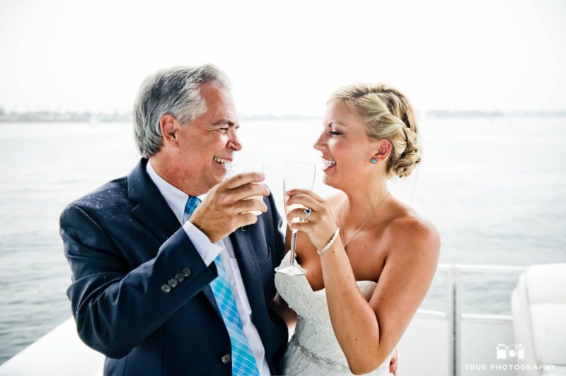 Bride laughs with Father as they share toast after wedding ceremony