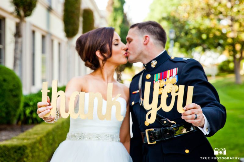 Military Groom in Uniform kisses Bride as they hold Thank you Sign