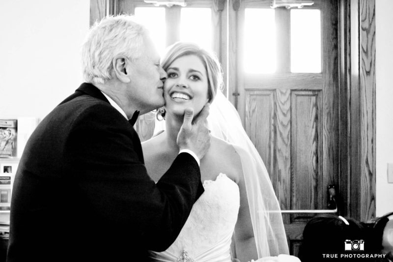 Bride's Father kisses bride on cheek before wedding ceremony