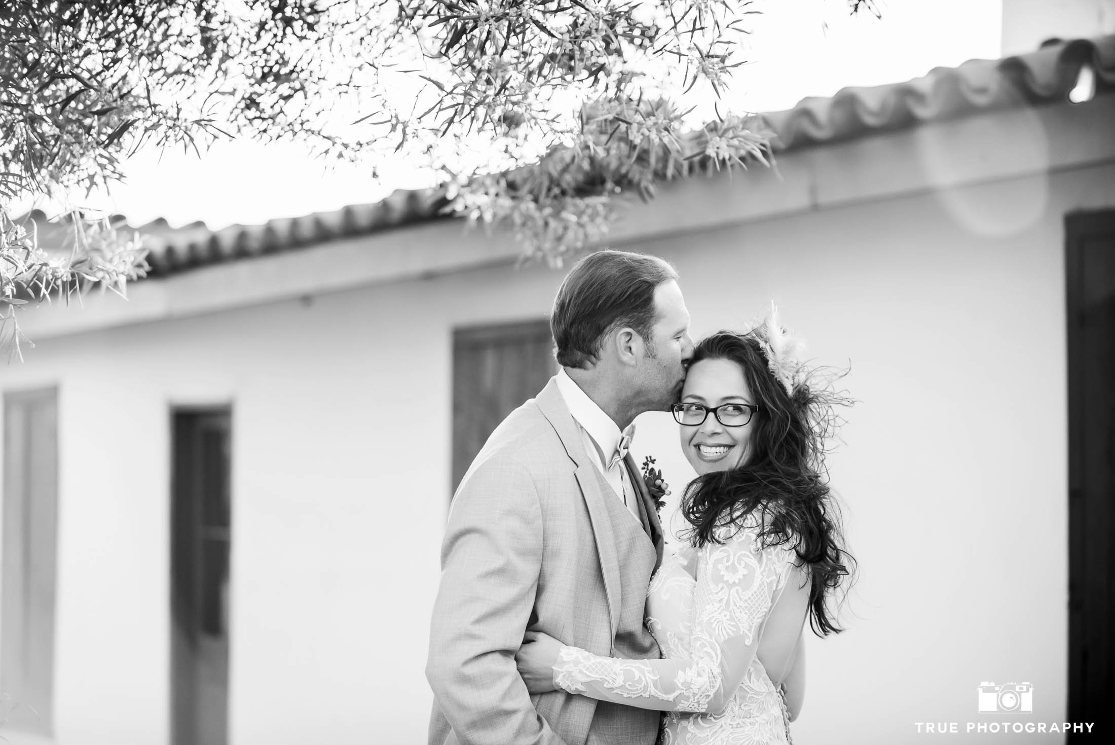 Black and white photo of Groom Kissing Bride