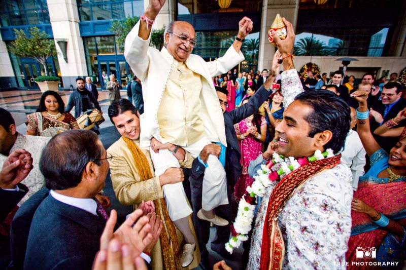 Guests lift up Groom's Father during Indian wedding
