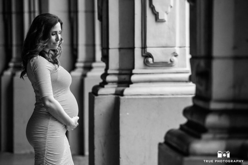 Expecting mother holding belly during maternity session at Balboa Park