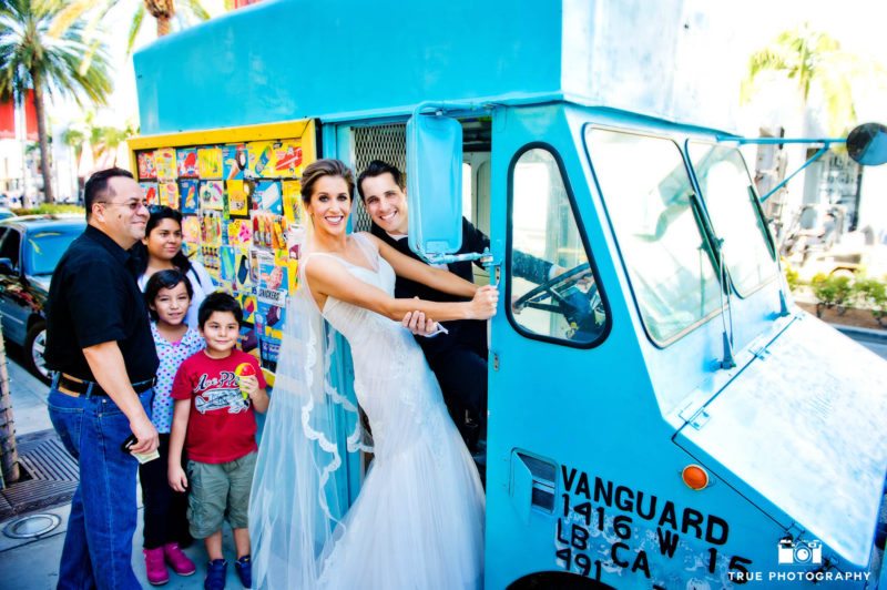 Bride and Groom stand in door of ice cream truck after wedding ceremony