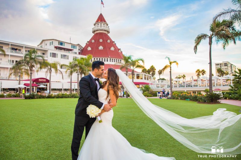 Groom dips Bride for kiss in front of Hotel Del Coronado