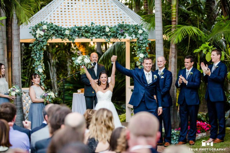 Bride and Groom cheer as they walk down aisle after wedding ceremony
